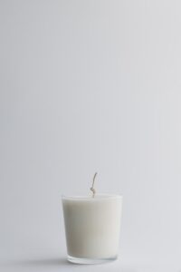 A white candle in a glass jar